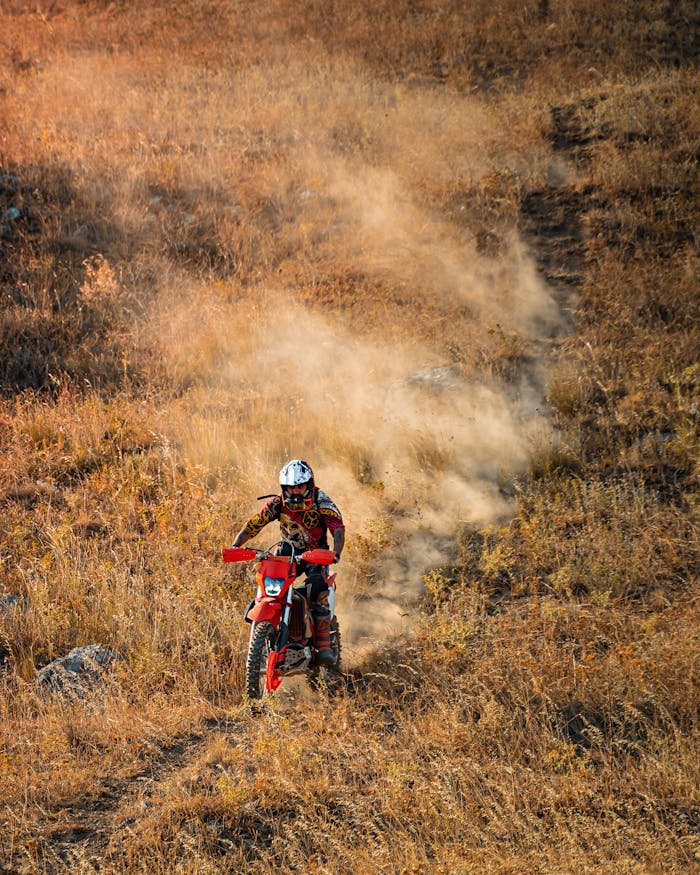 A motocross rider on a dusty trail in Gündoğdu, Turkey, showcasing skill and adventure.