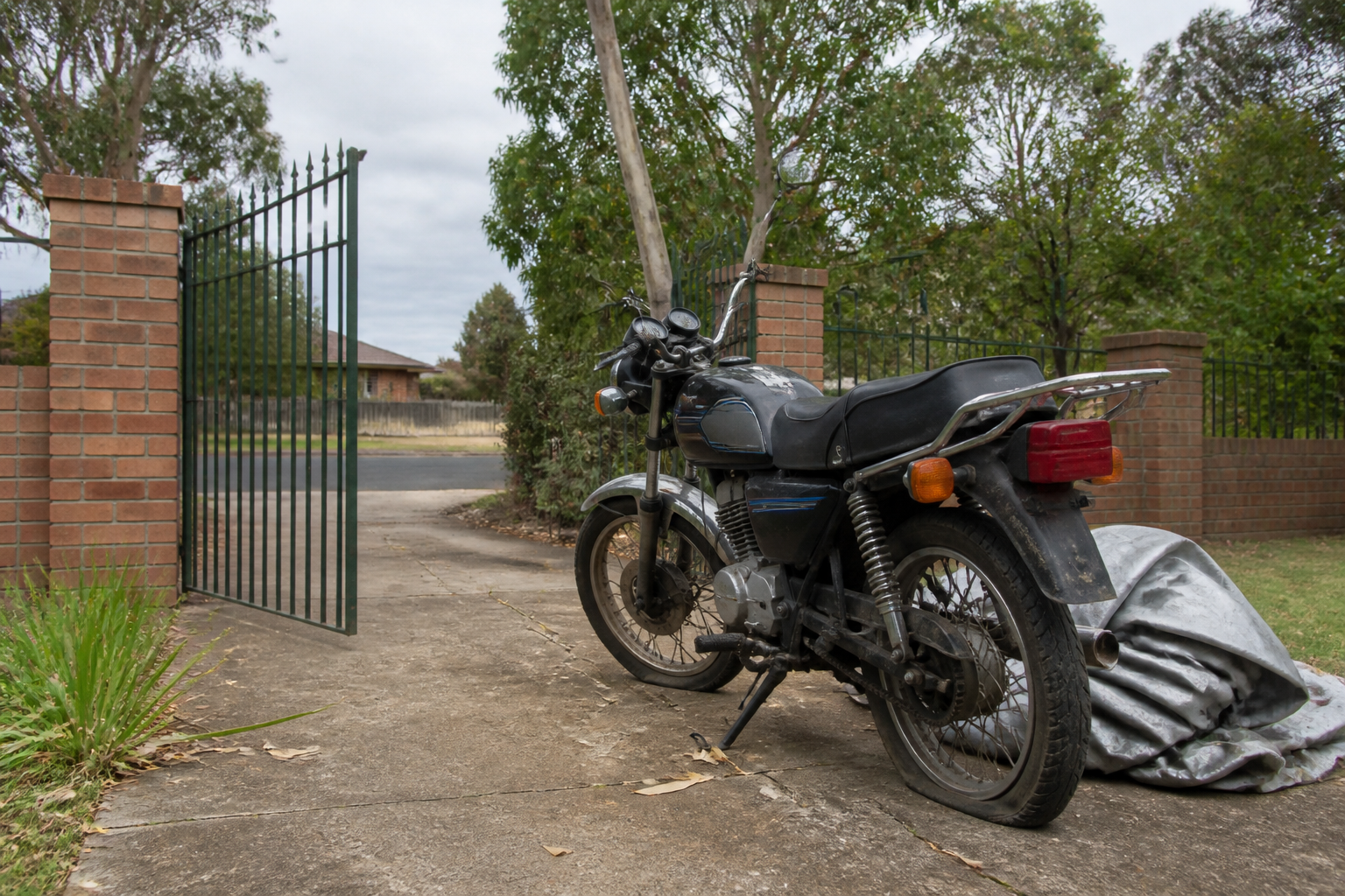 Old motorcycle beside an open gate in a Ballarat driveway